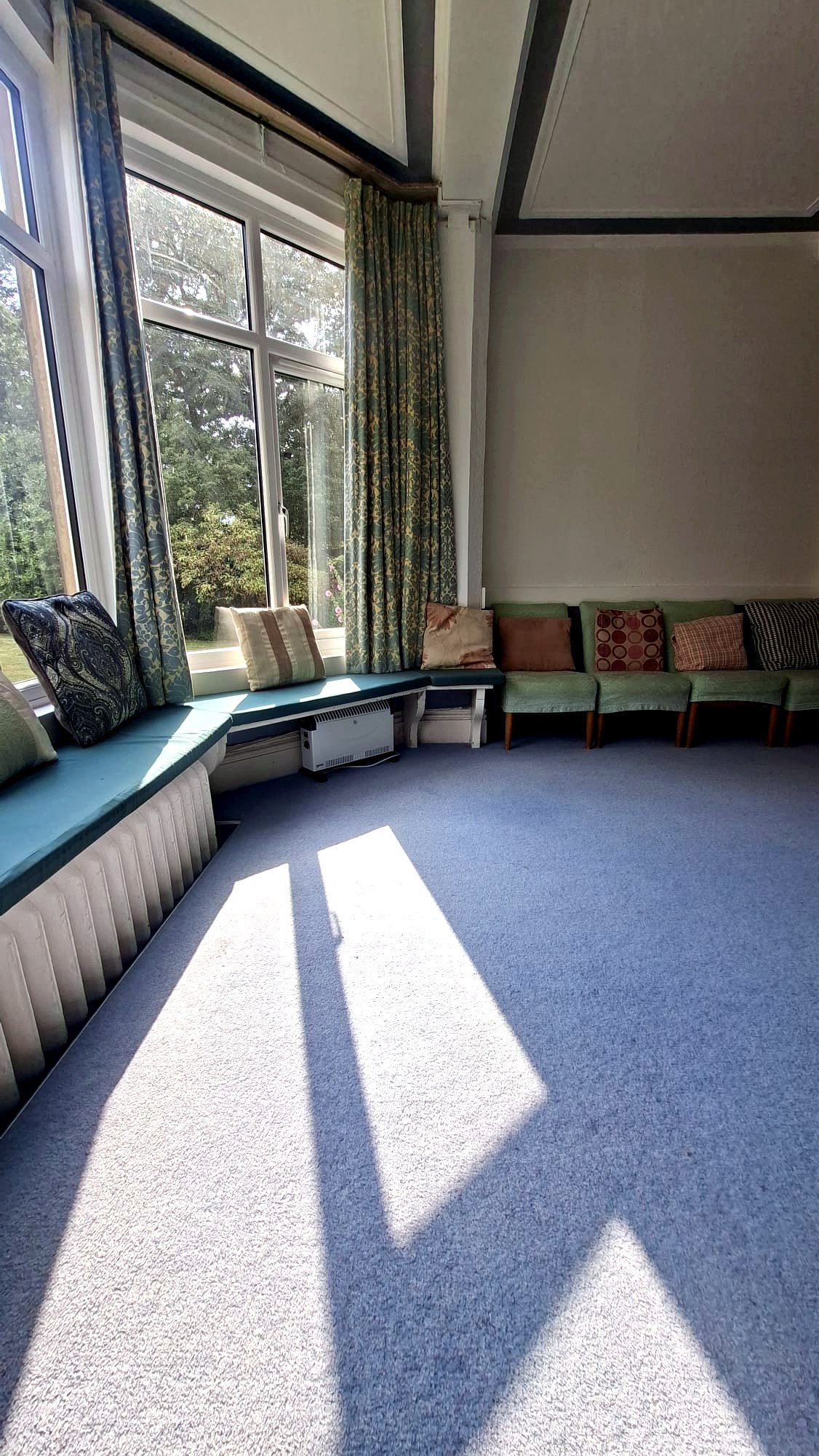 Bright room with window seat and chairs along the wall